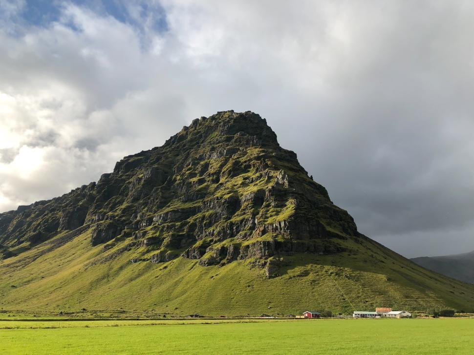 Free Image of Majestic mountain landscape with green hills and cloudy sky 