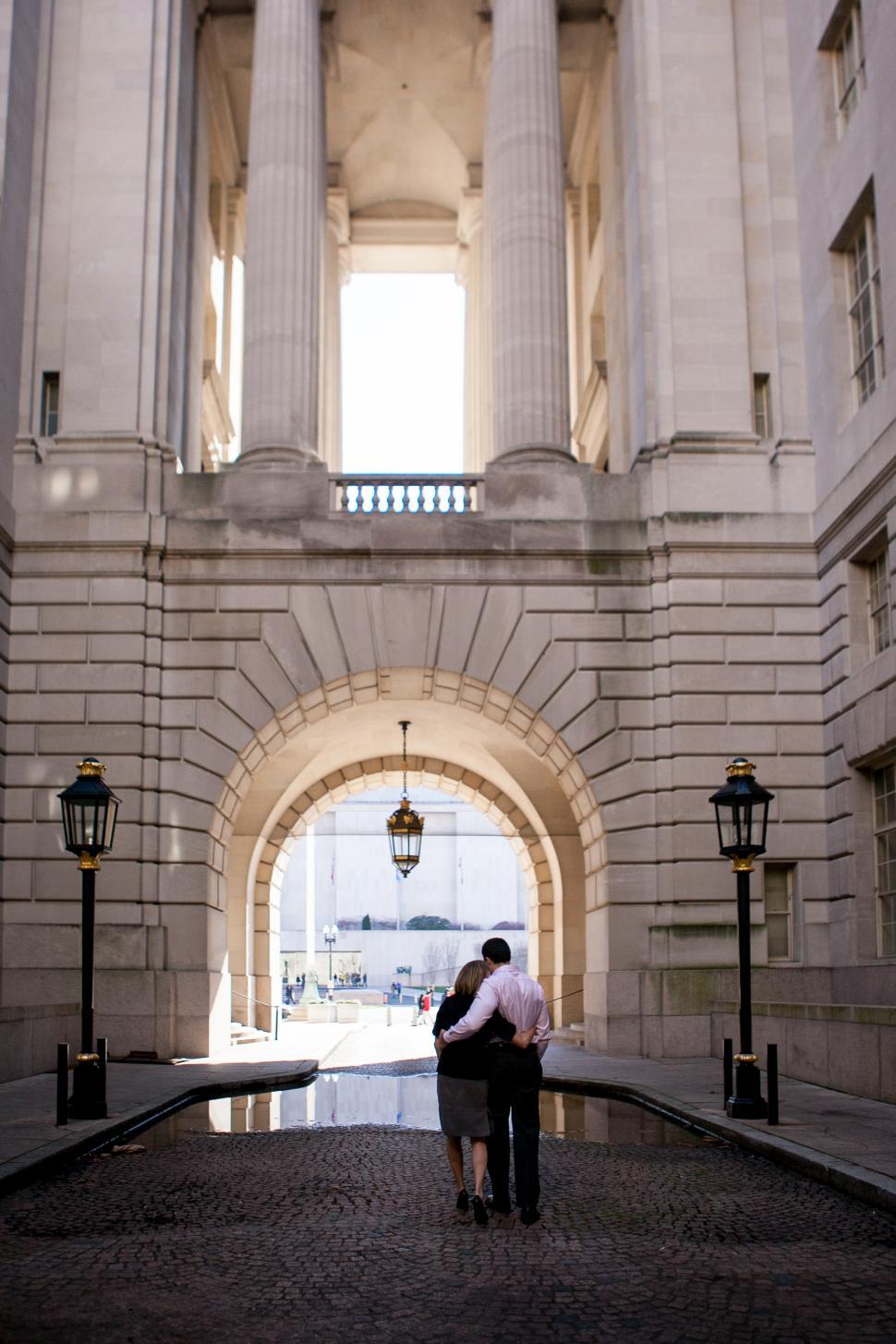 Free Image of Couple enjoying a romantic moment in an elegant city archway 