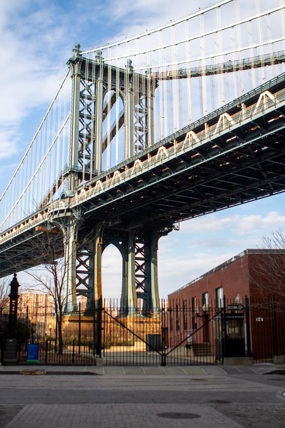 Free Image of View of the Manhattan Bridge towering over the streets in Brooklyn at sunset 