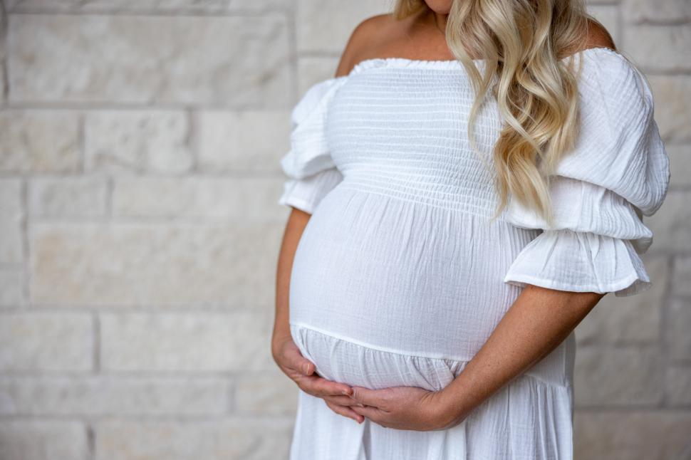 Free Image of Expecting mother poses gracefully showcasing her baby bump 