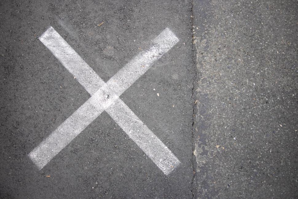 Free Image of White cross marking on asphalt surface indicating no parking or stopping area 
