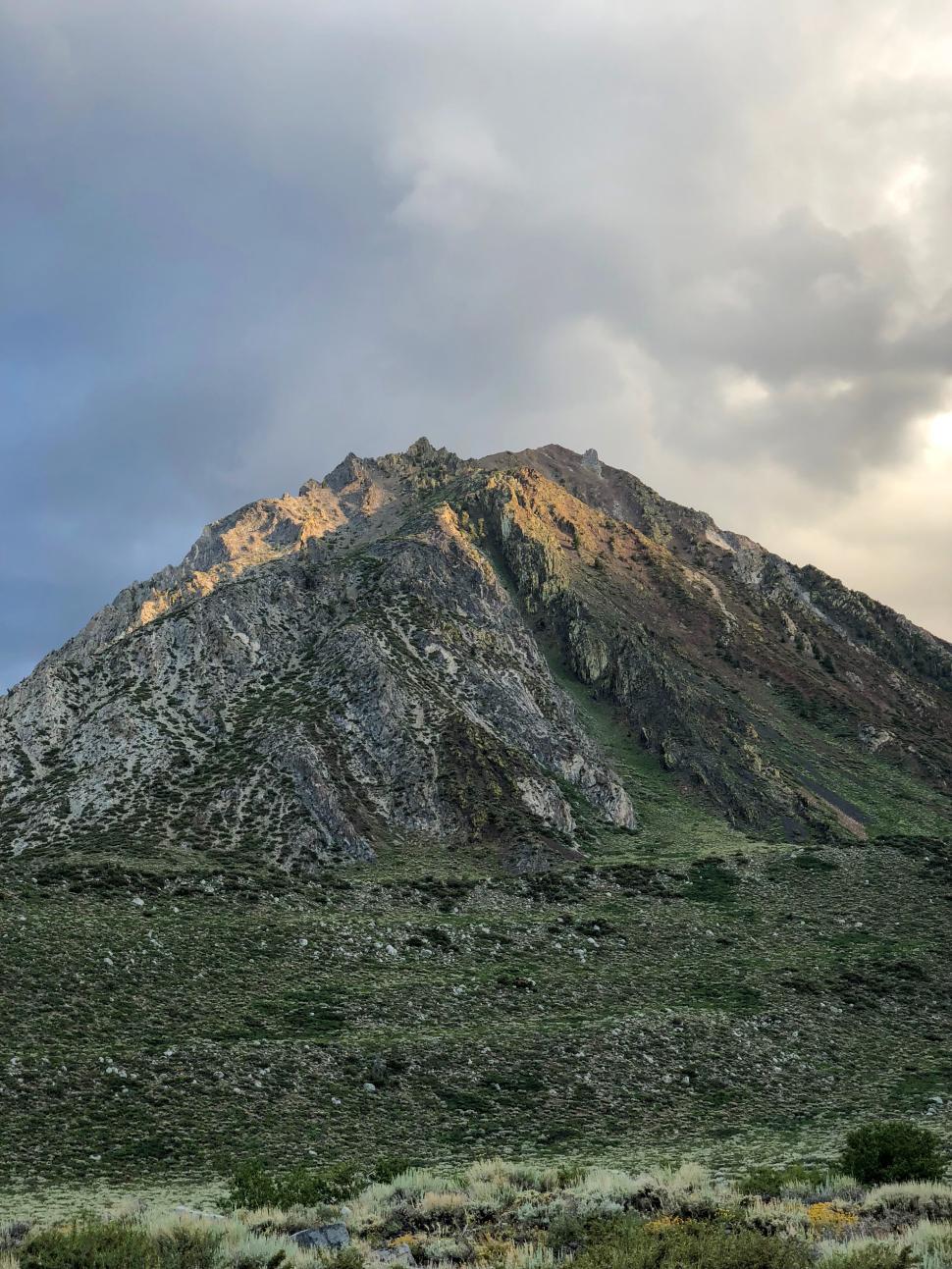 Free Image of Mountain peak illuminated by sunset in a tranquil setting 