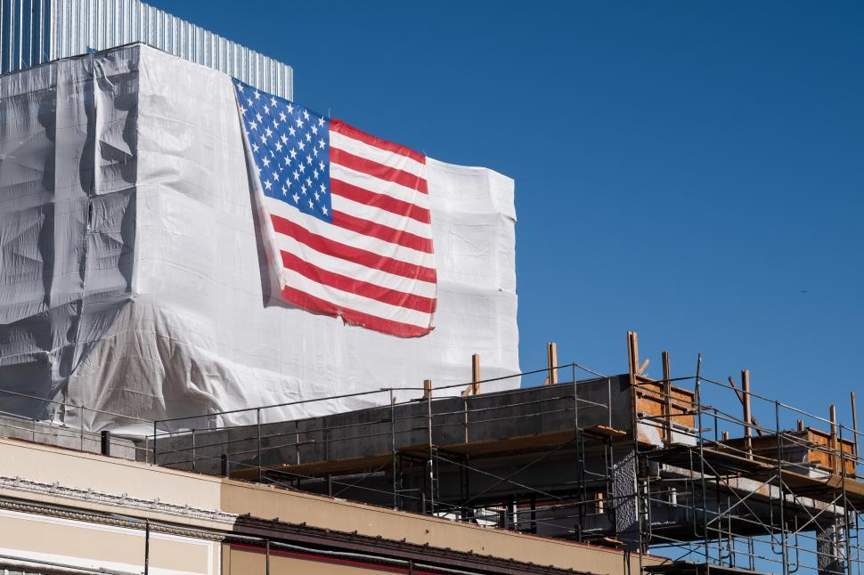 Free Image of Construction site with scaffolding and American flag on building 
