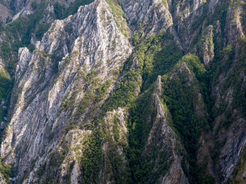 Free Image of Mountain landscape with rocky formations and greenery at sunset 
