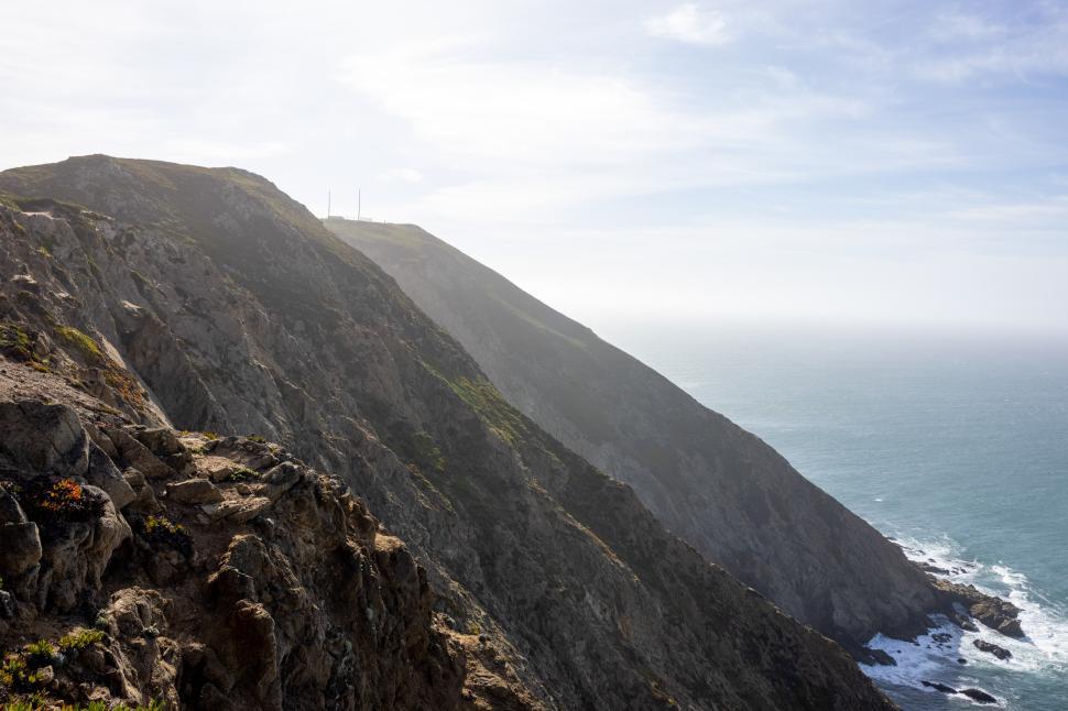 Free Image of Scenic coastal cliffs overlooking the ocean on a misty day 