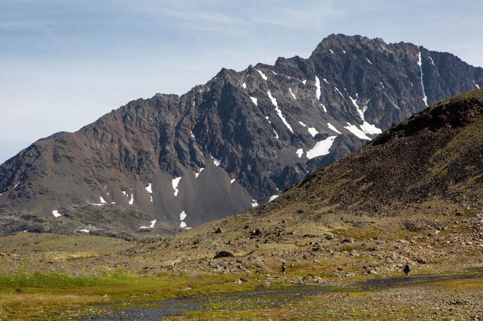Free Image of Mountain landscape with hikers exploring in summer sunlight 