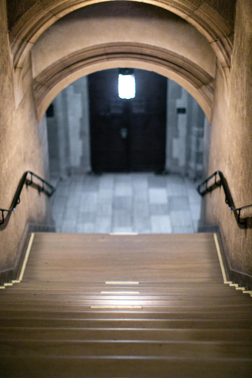 Free Image of Steps leading down into a historic stone corridor at dusk 