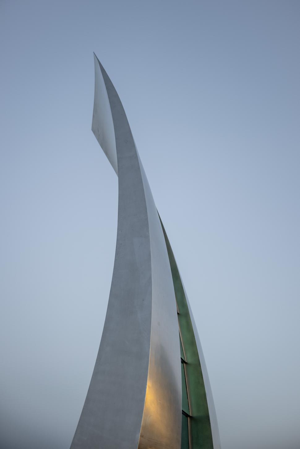 Free Image of Elegant modern sculpture reaches towards the sky at sunset 