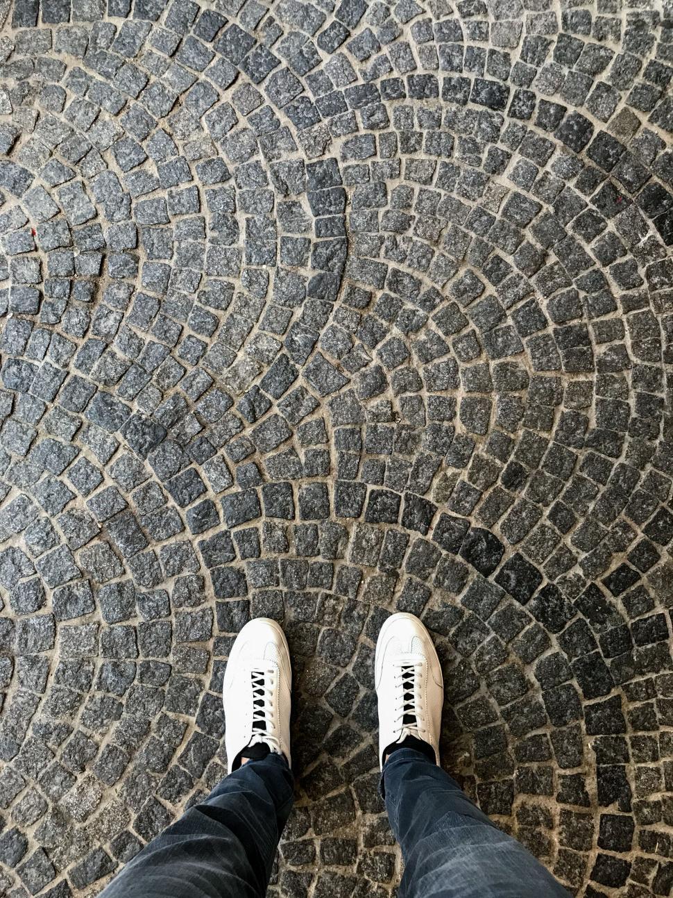 Free Image of Feet on intricate cobblestone path in urban setting 