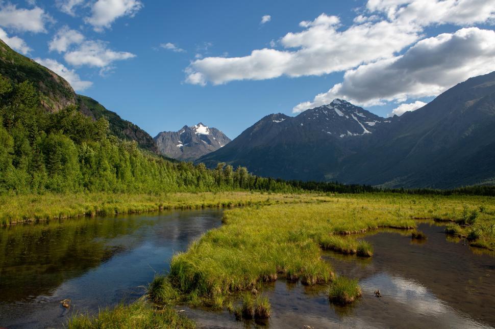 Free Image of Mountain landscape with river and greenery under blue sky 