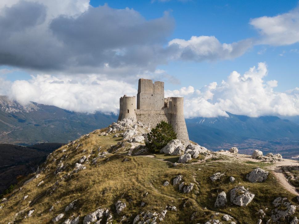 Free Image of Historic castle on a hill under dramatic clouds in Italy 