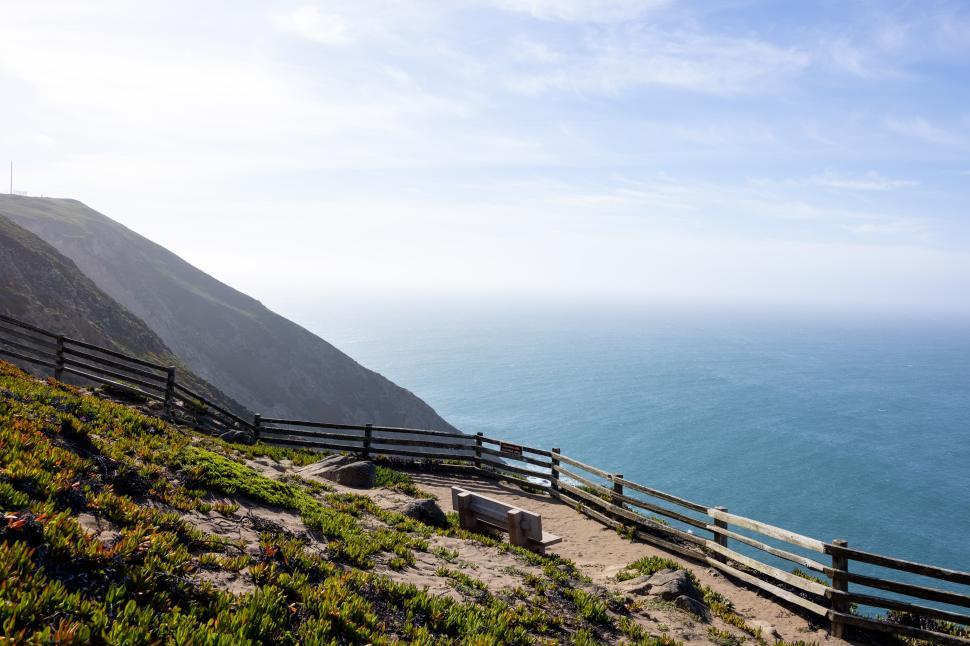 Free Image of Scenic coastal view with gentle ocean waves and rugged cliffs 