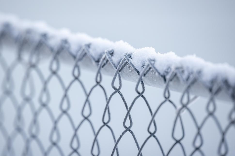 Free Image of Snow covers a chain-link fence during a winter morning 