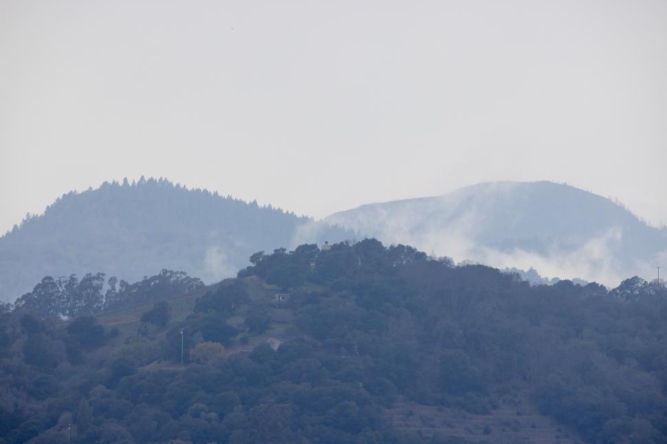 Free Image of Misty mountain landscape with rolling hills and trees 