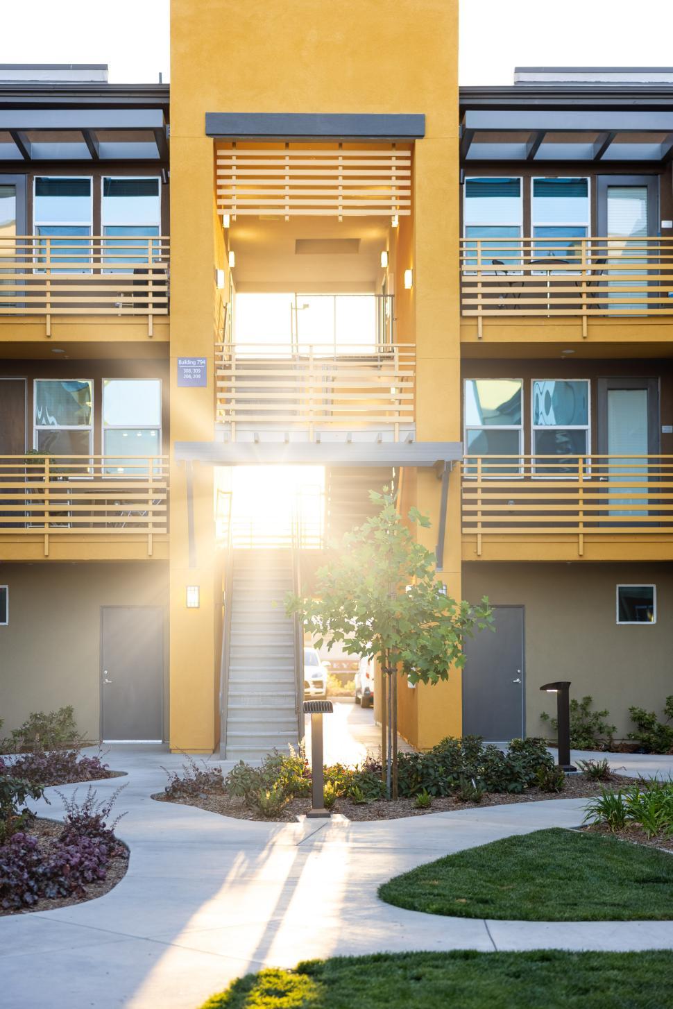 Free Image of Bright sunlight shines through modern apartment building entrance 