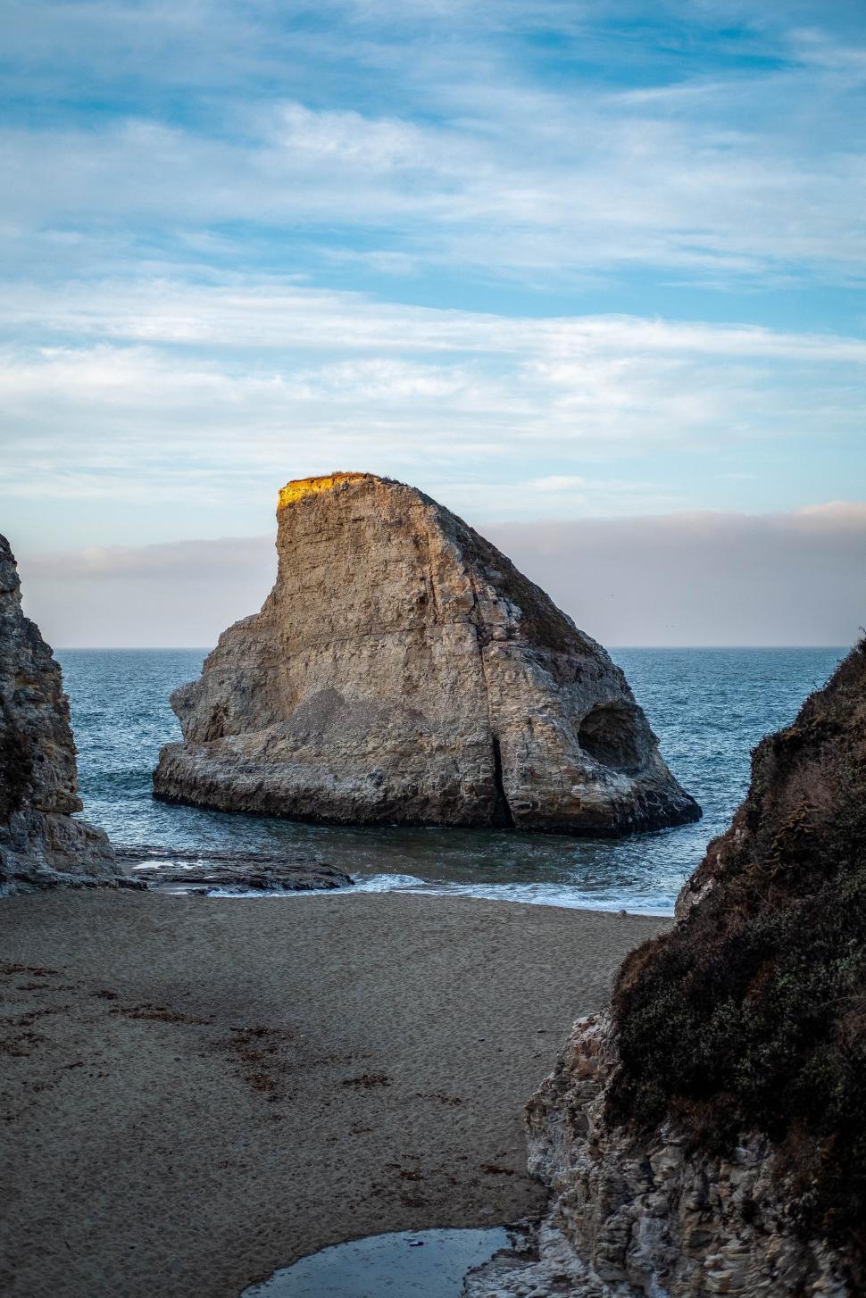 Free Image of Secluded coastal rock formation at sunset near sandy beach 