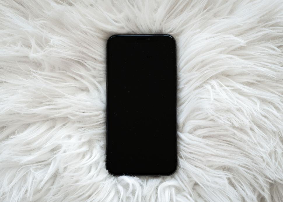 Free Image of Modern smartphone resting on a fluffy white surface 