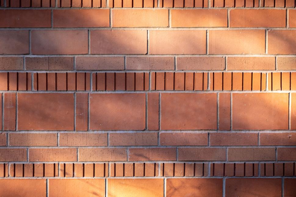 Free Image of Textured red brick wall with shadows from sunlight 