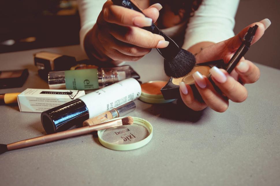 Free Image of Applying makeup with various products and tools on a table 