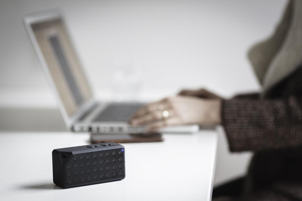 Free Image of Working at a desk with a portable speaker and laptop 
