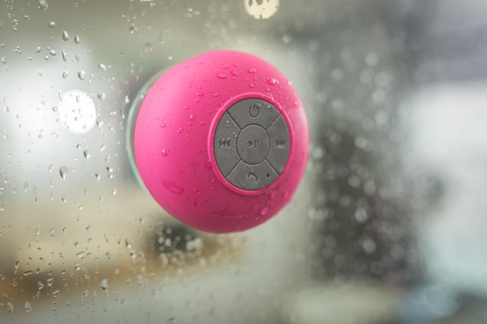 Free Image of Colorful waterproof speaker attached to a shower wall 