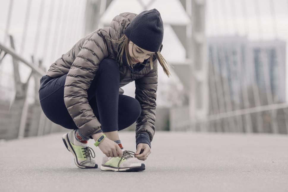 Free Image of Runner prepares for exercise on an urban bridge 