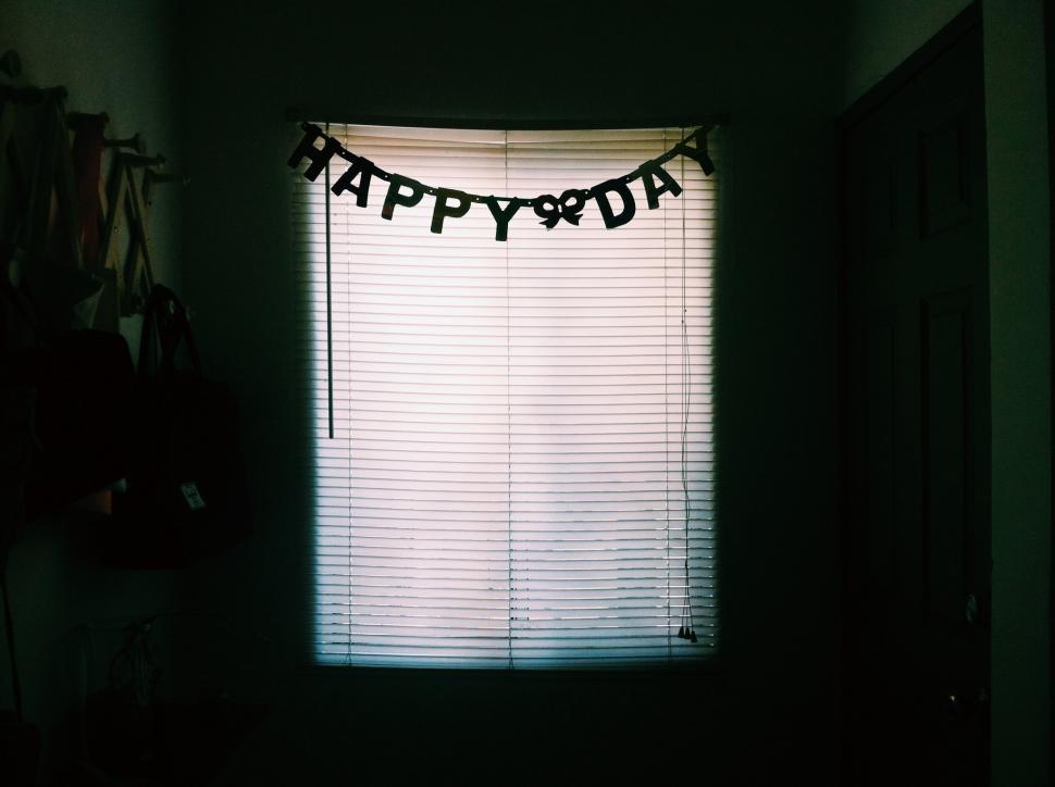 Free Image of Happy birthday banner displayed in a dimly lit room 