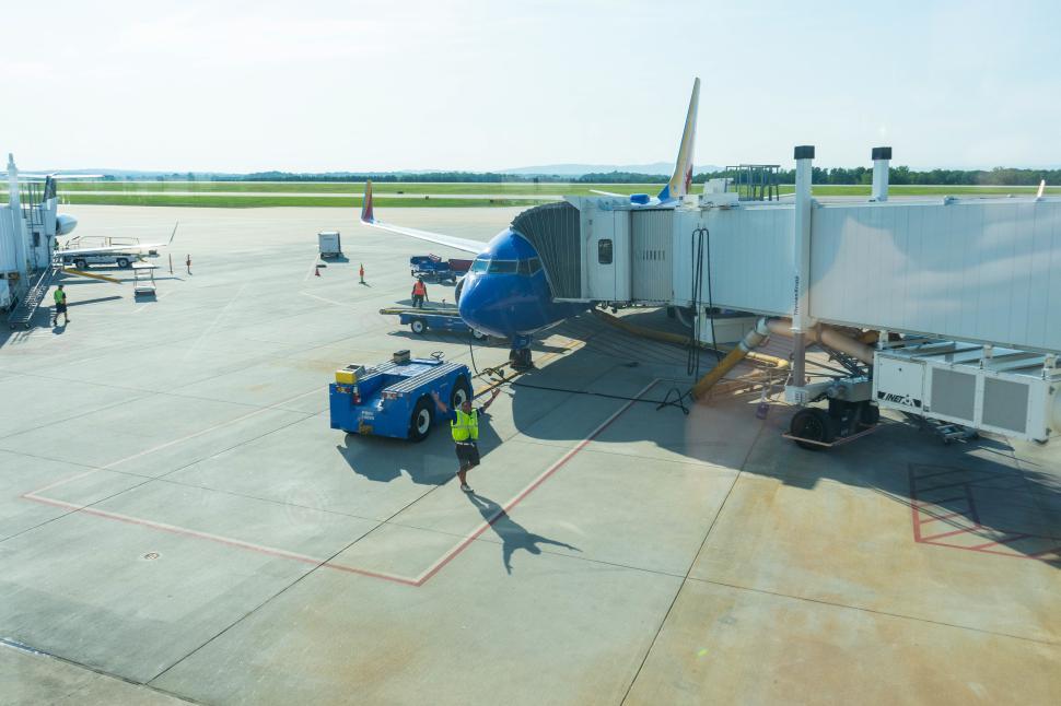 Free Image of Ground crew prepares aircraft at airport on sunny day 