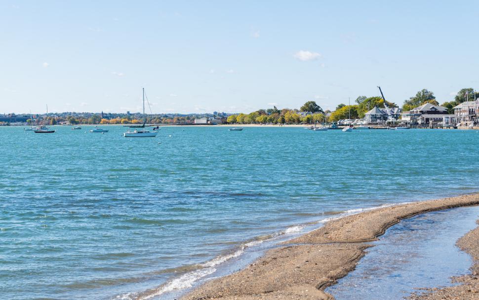 Free Image of Boats on a calm lake near a sandy shore in autumn 