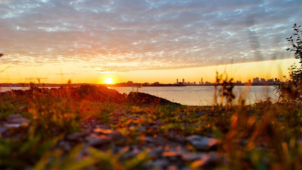 Free Image of Beautiful sunset over the city skyline by the waterfront 