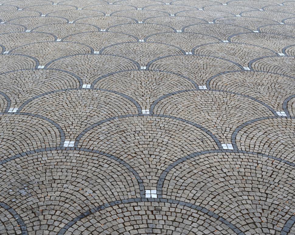 Free Image of Cobblestone pattern displays intricate design in historic city square during daylight 