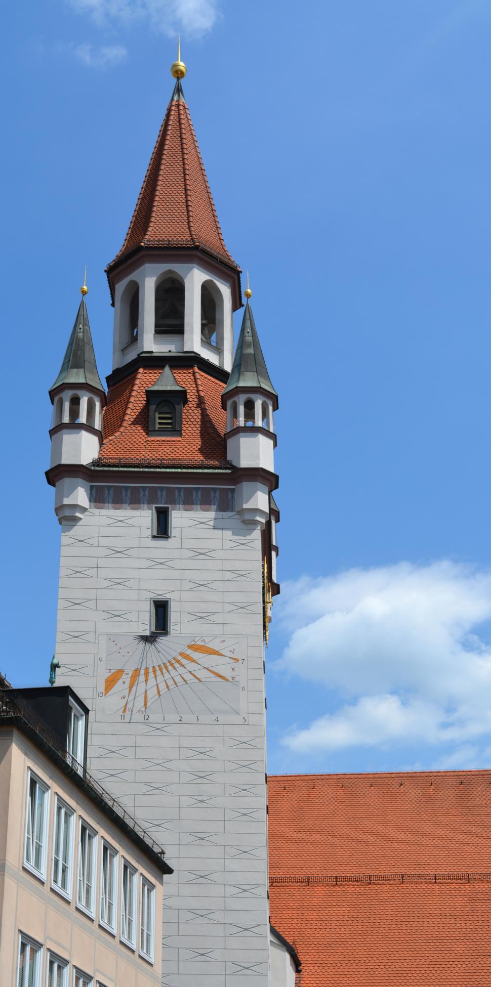 Free Image of Historic tower with clock and intricate details against blue sky 