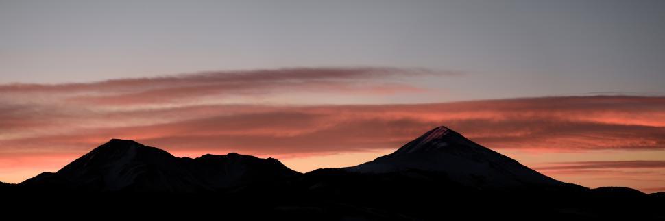 Free Image of Observing a colorful sunset over mountain peaks in serene nature landscape 