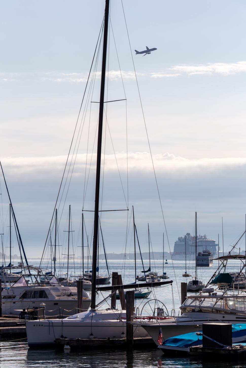 Free Image of Boats and airplanes at a coastal marina during twilight 