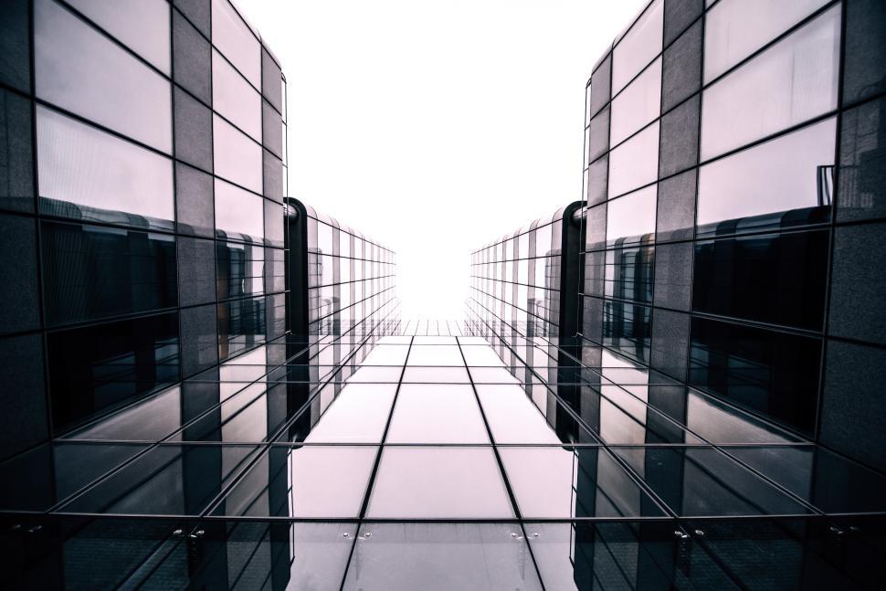 Free Image of Glass buildings merge into bright sky in urban setting 