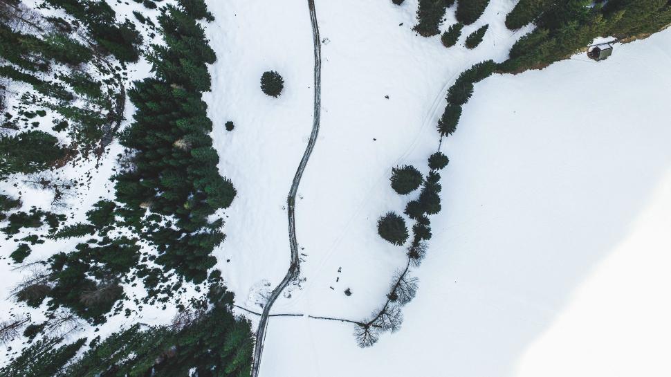 Free Image of Snow-covered landscape with winding path and trees in winter serenity 