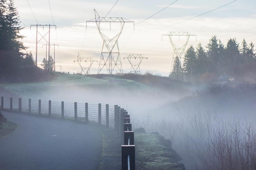 Free Image of Electricity and fog enhance a serene landscape at dawn 