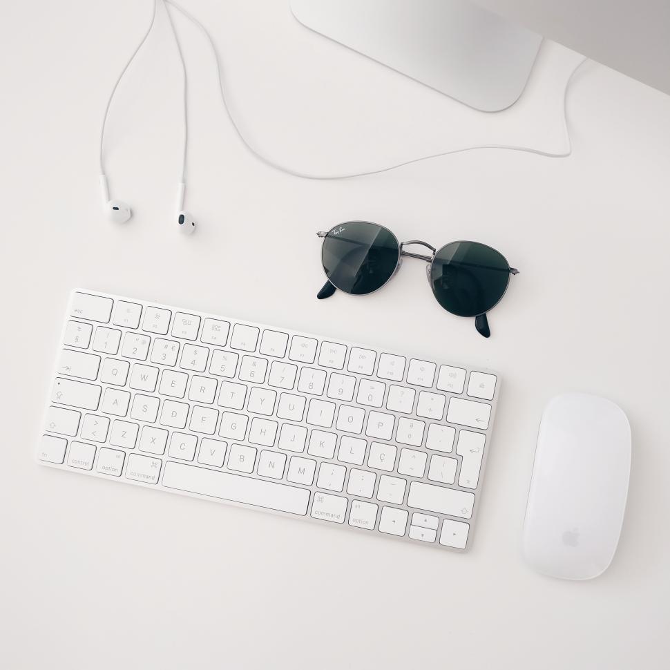 Free Image of Workspace setup featuring a keyboard, mouse, and sunglasses 