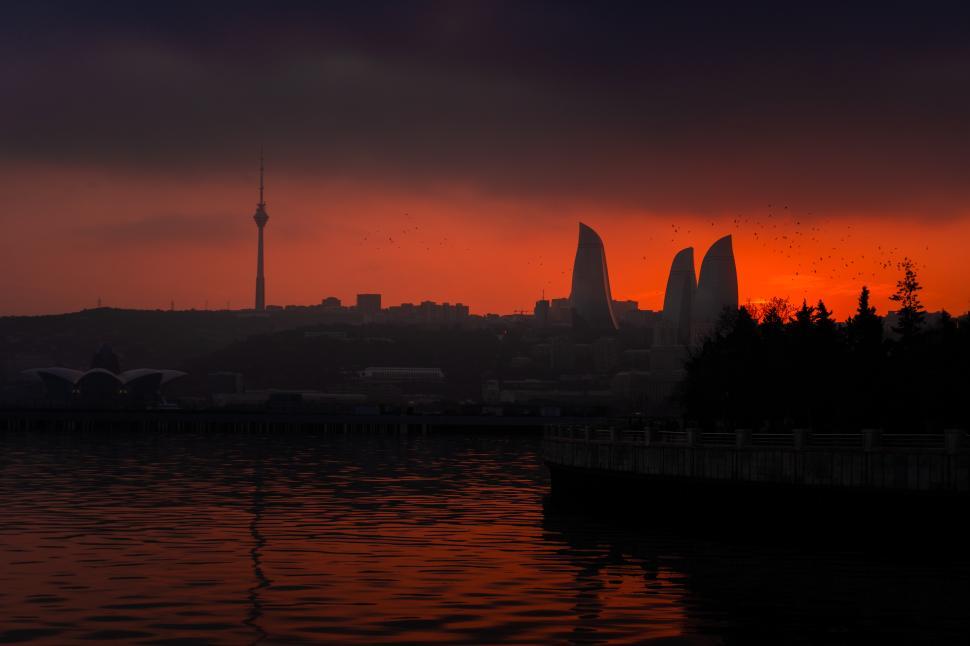 Free Image of Urban cityscape of Baku, Azerbaijan, under a stunning evening sunset, featuring the modern skyline bathed in warm golden light and a vibrant metropolitan atmosphere.  