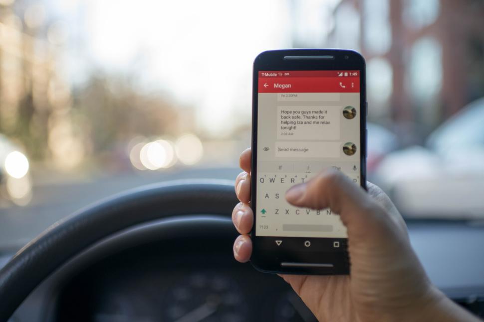 Free Image of Sending a text while driving in a city setting 