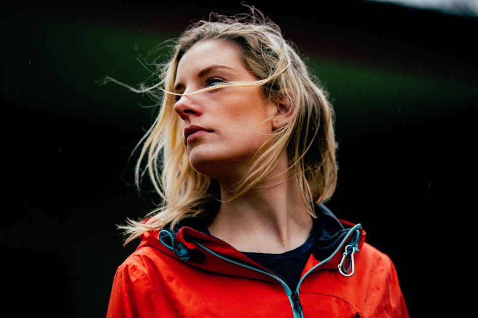 Free Image of Woman with windblown hair in a vibrant red jacket 