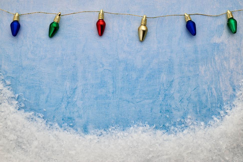 Free Image of Colorful holiday lights above a snowy background 
