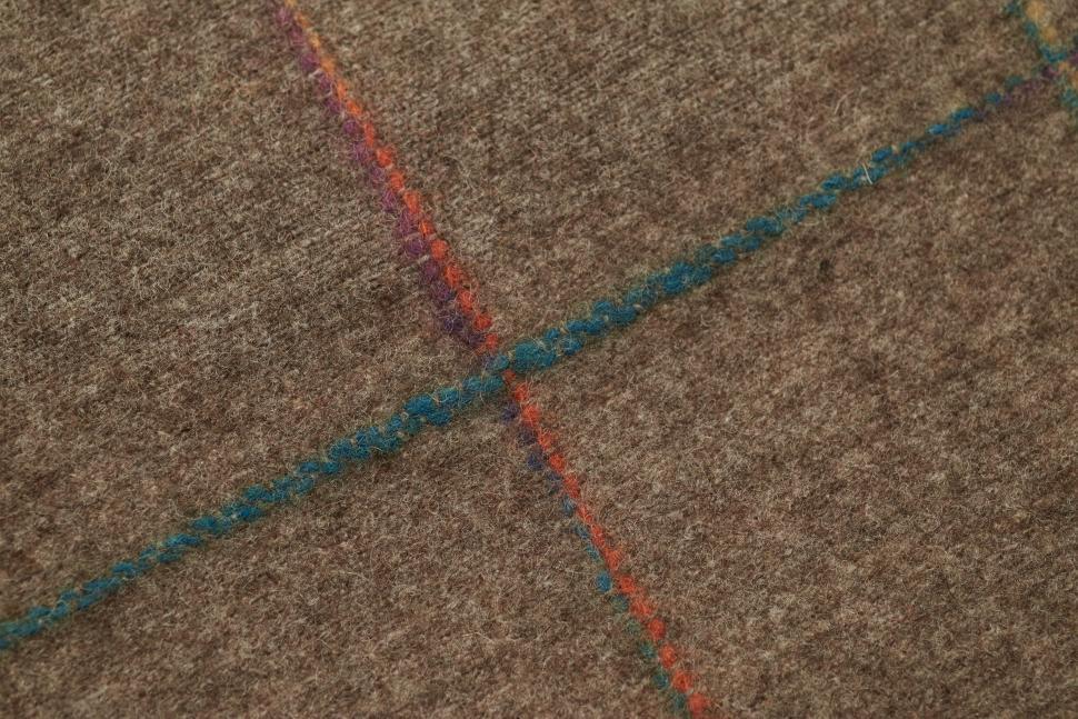 Free Image of Textured brown fabric with colorful stitching patterns showcasing craftsmanship 
