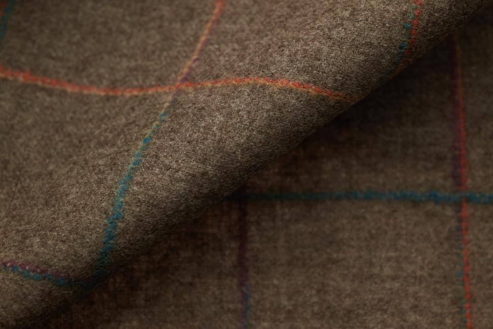 Free Image of Texture and detail of a brown textile with colorful grid patterns 