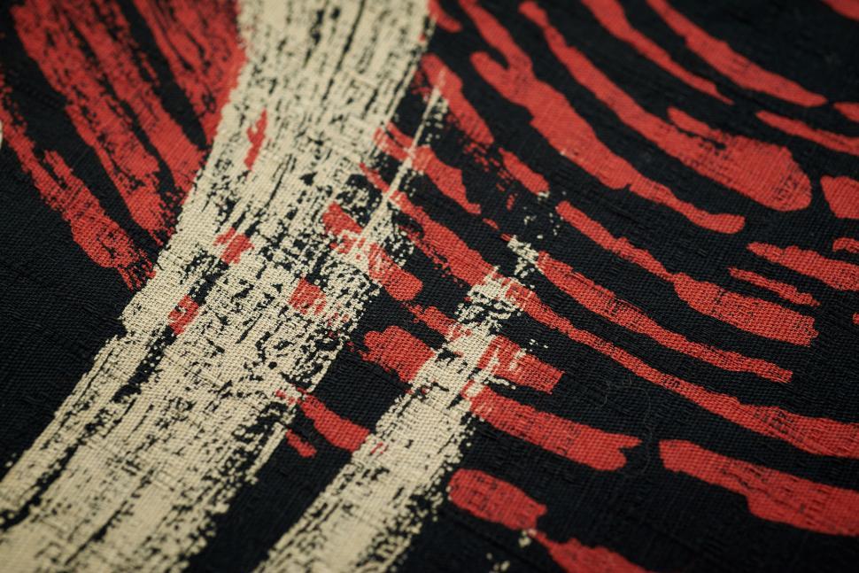 Free Image of Textured fabric with intricate red and black patterns 