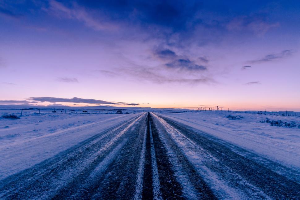 Free Image of Snow-covered road stretching into a winter sunset in a rural landscape 