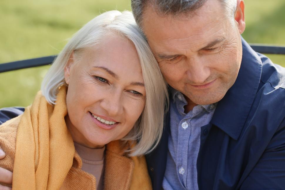 Free Image of Couple enjoying a warm moment outdoors in a park 
