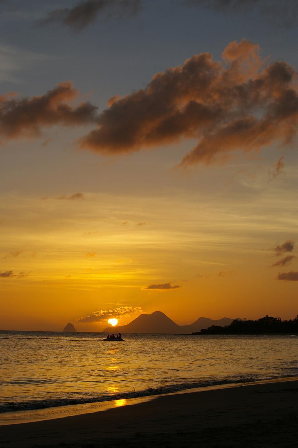 Free Image of Sun Setting Over Ocean With Boat 