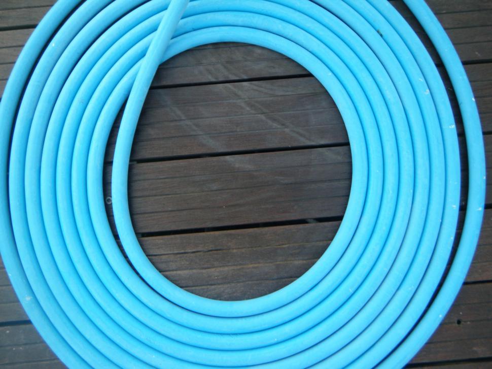 Free Image of Coil of rubber water hose lying on a deck - blue 