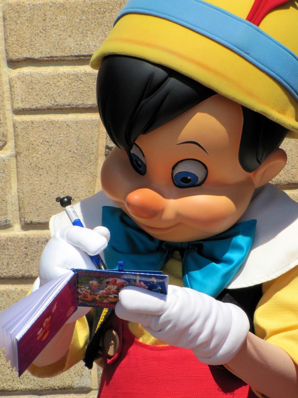 Free Image of Mascot Holding a Book 
